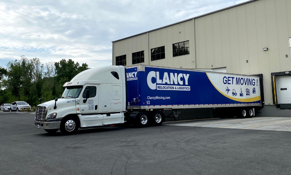 Clancy semi-truck backed into a loading dock at a large warehouse