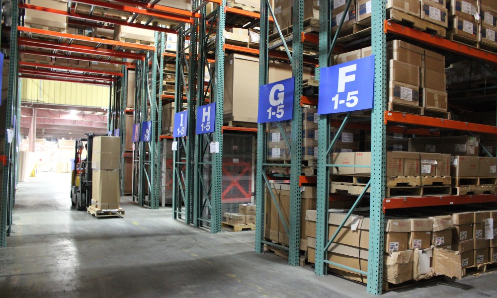 An aisle between tall industrial storage racks in a warehouse