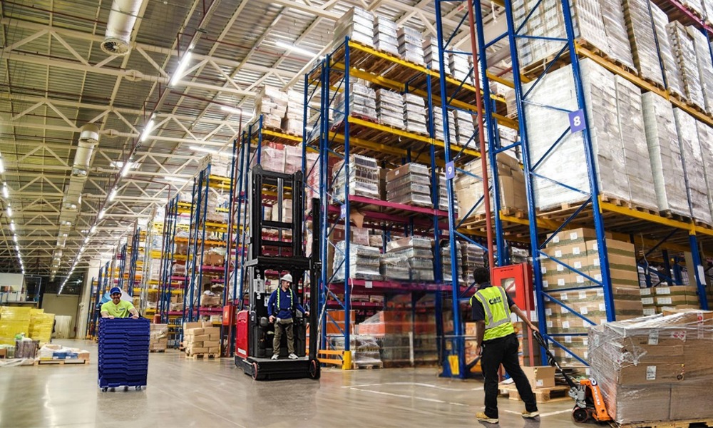 Workers operating forklifts and pallet jacks